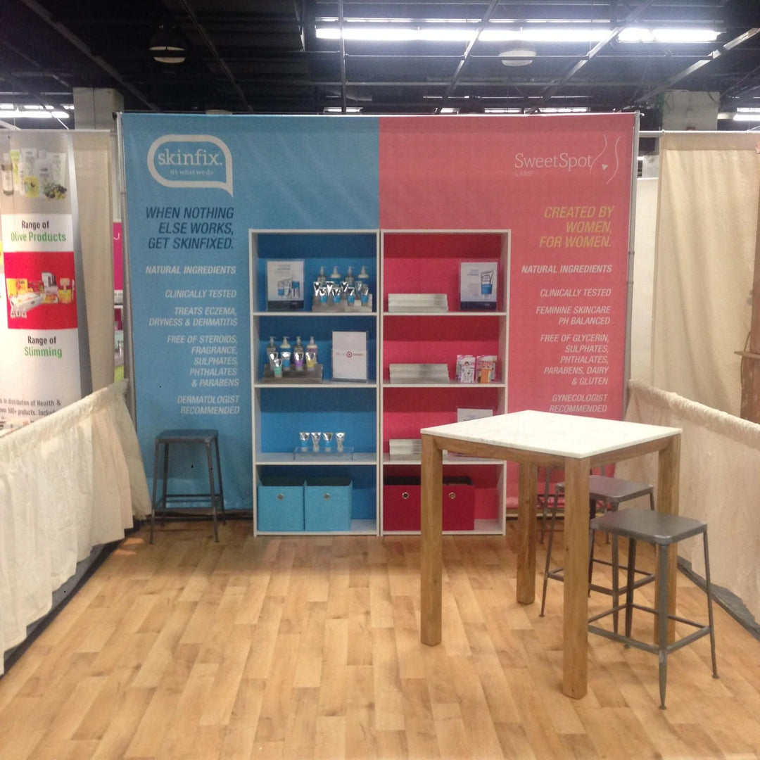 Trade show booth with Skinfix and SweetSpot Labs pop up banner stands, displaying skincare products on shelving units