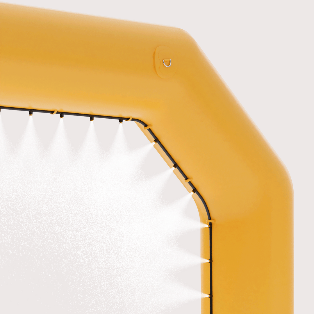 Close-up of a corner of a yellow misting inflatable arch, with water droplets visible, for outdoor events.