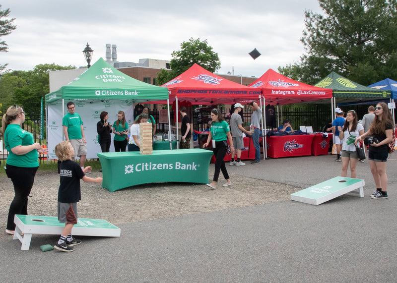 an array of 10 x 10 custom canopy tents with attendees playing a game in the foreground