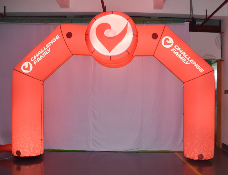 Illuminated red inflatable arch with Challenge Family branding, set up indoors for an event or photo shoot