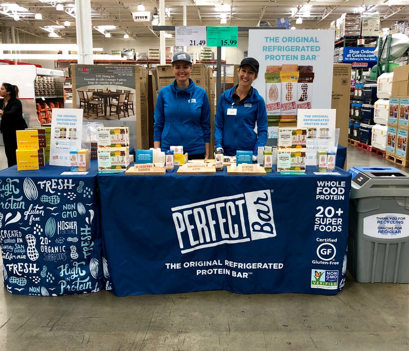 Promotional table runner with Perfect Bar logo at a Costco sampling event