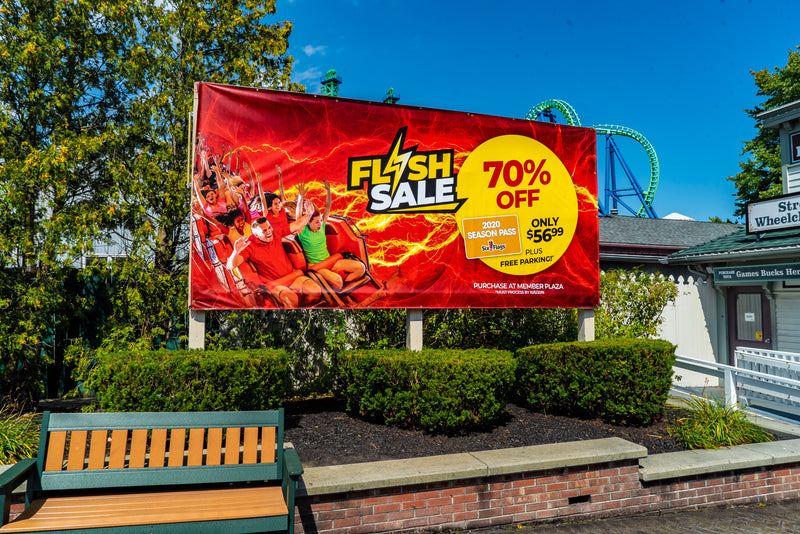 custom outdoor vinyl banners with 70% off flash sale messaging hanging in six flags amusement park