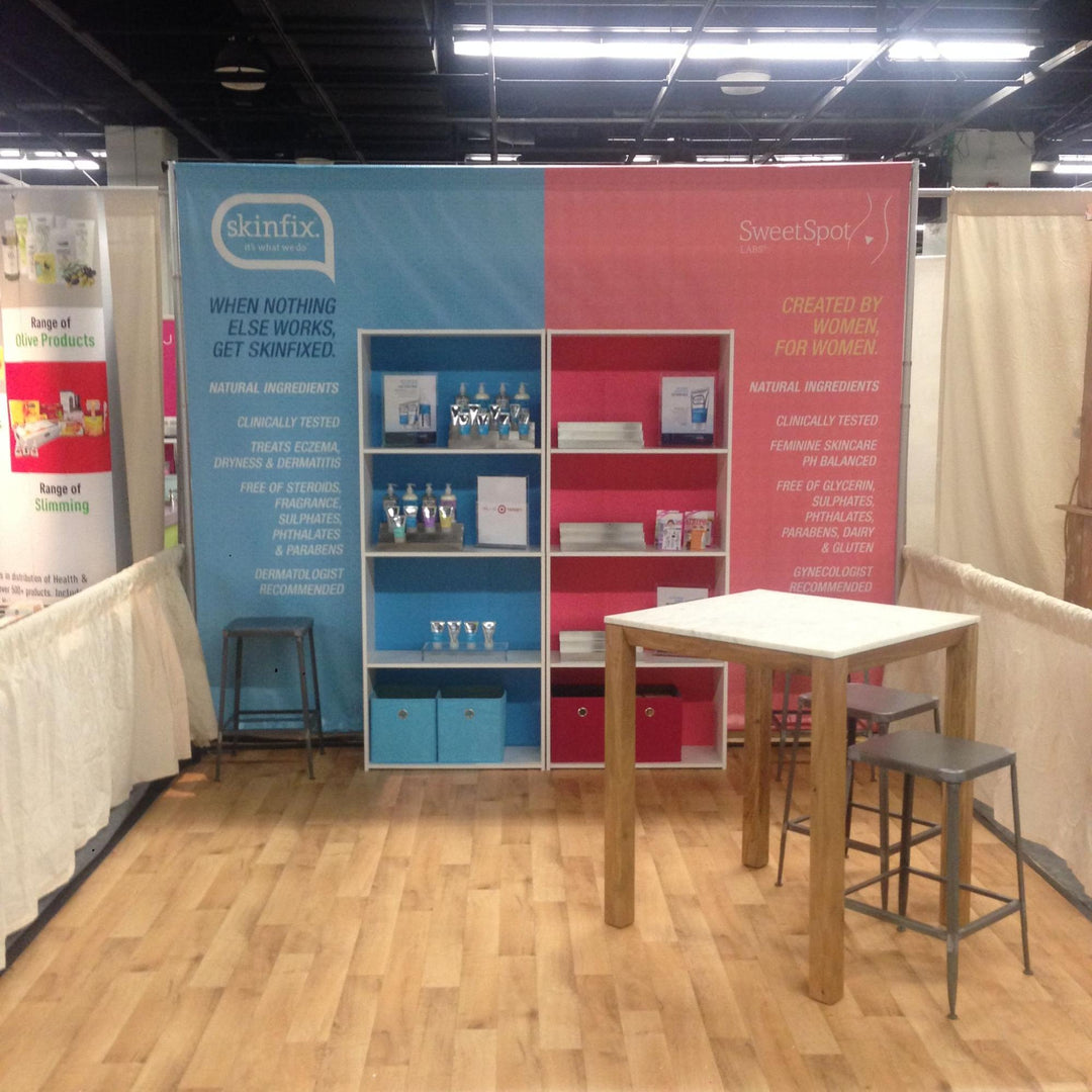 Trade show booth featuring Skinfix and SweetSpot Labs branding with product displays and an informational backdrop