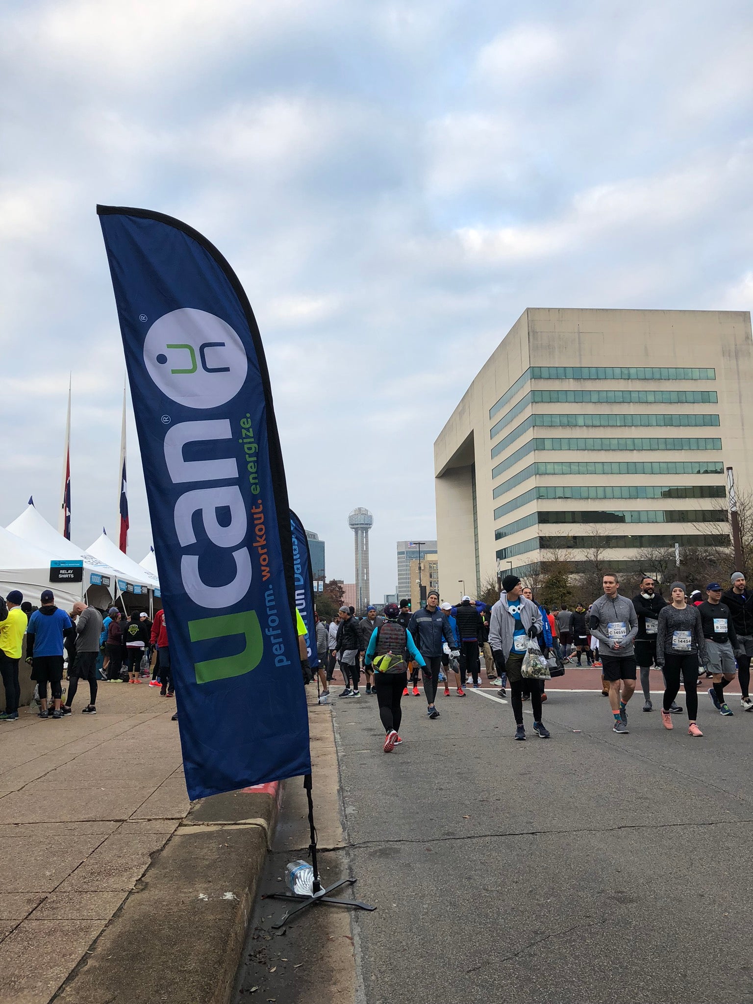 blade style feather flag prominently displayed along the side walk of ucan nonprofit outdoor run and walk event