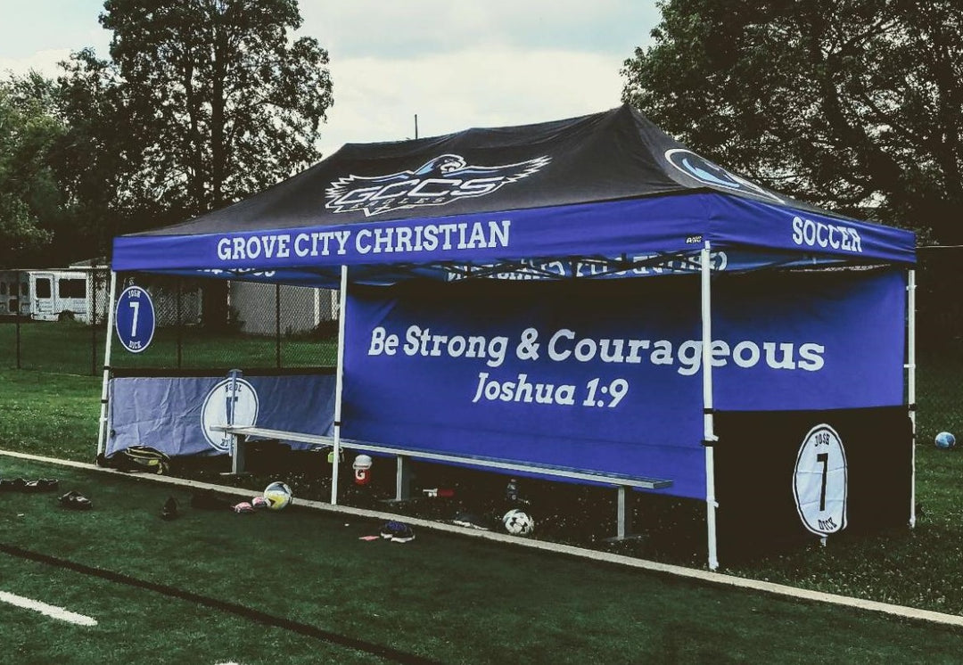 Blue Grove City Christian school canopy with inspirational quote on soccer field