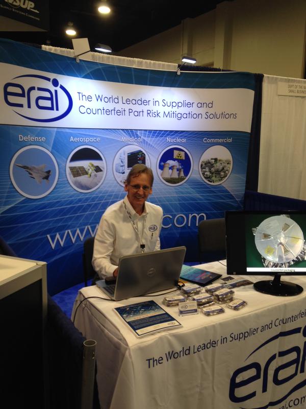 Man at ERAI trade booth with curved tension backdrop display and products