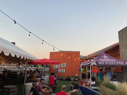 Twilight scene at an outdoor restaurant tent with patrons enjoying the ambient lighting and seating