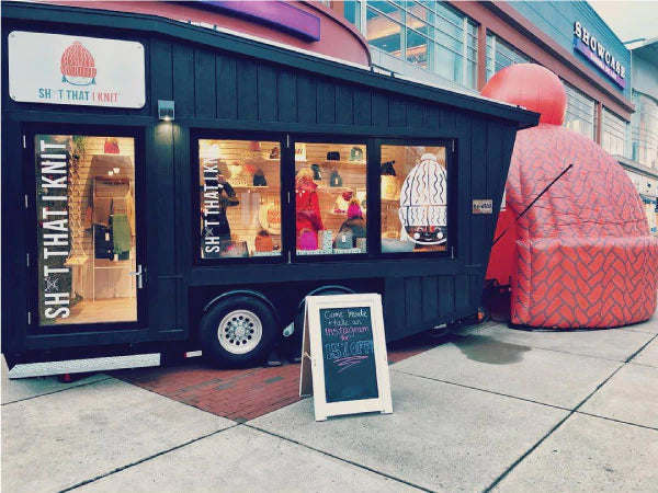 Knitwear pop-up store and matching oversized inflatable beanie hat on a city sidewalk