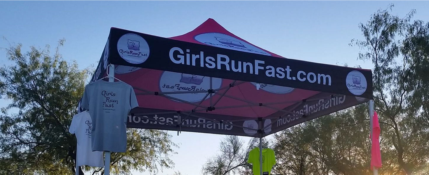 10x10 canopy fully set up for a running race meet with merch t-shirt draped on the valance part of canopy