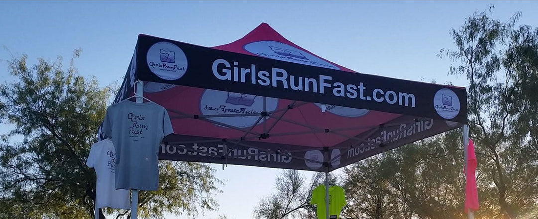 10x10 canopy fully set up for a running race meet with merch t-shirt draped on the valance part of canopy