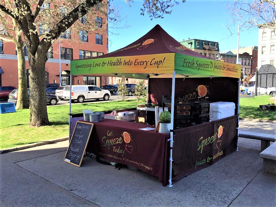 organic juice vendor booth at a farmers market