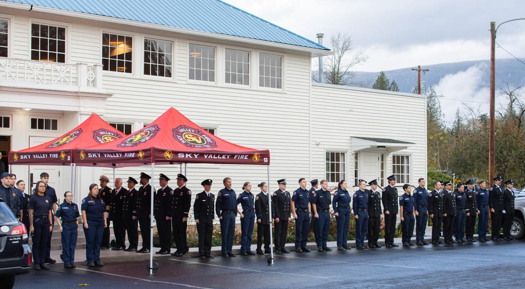 Sky Valley Fire Department personnel standing in formation under custom red canopy tents during a formal outdoor event.