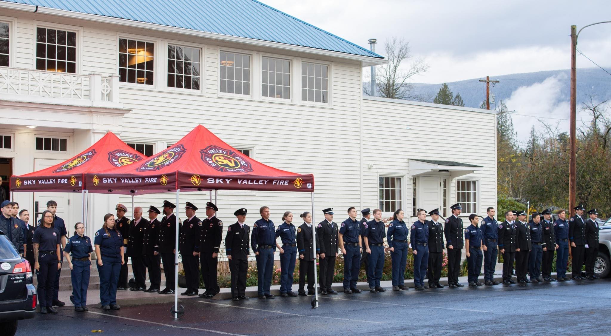 Sky Valley Fire Department personnel standing in formation under custom red canopy tents during a formal outdoor event.