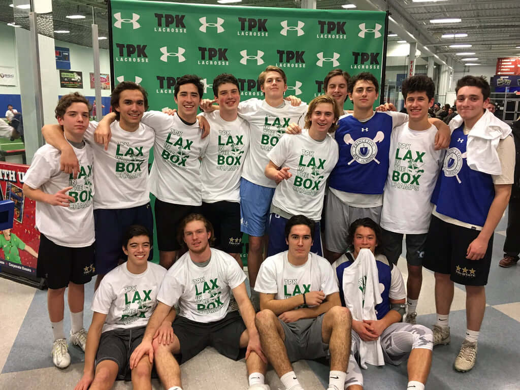High school lacrosse team posing in front of TPK Lacrosse and Under Armour step and repeat banner