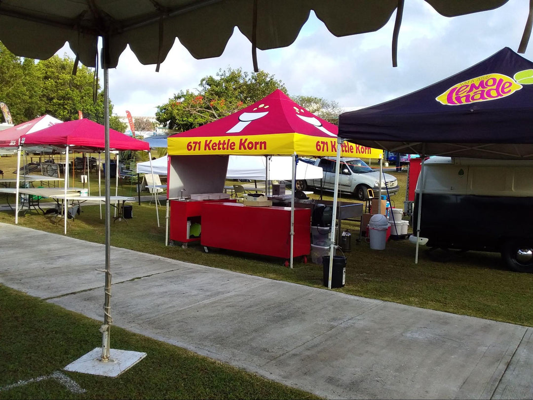 Colorful 10x10 food vendor tents for '671 Kettle Korn' and 'Lemonade' at outdoor event