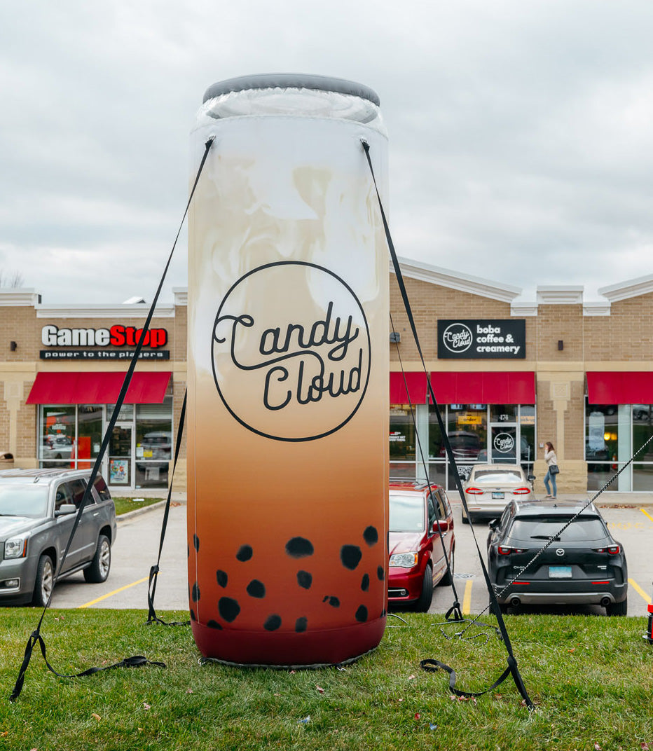 Giant inflatable boba drink outside Candy Cloud drawing attention from the parking lot