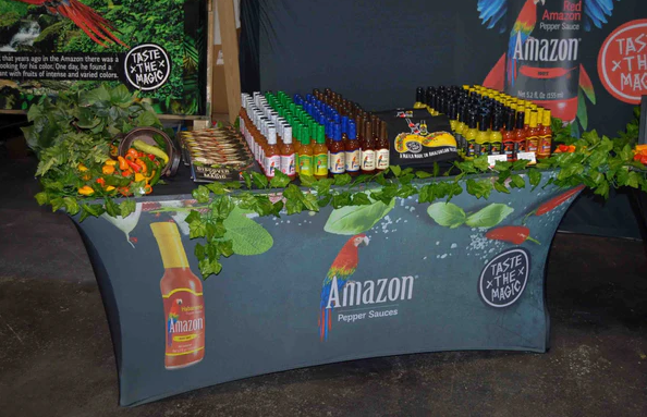 Custom stretchy trade show table cover featuring Amazon Pepper Sauces, with a vibrant product display and branding