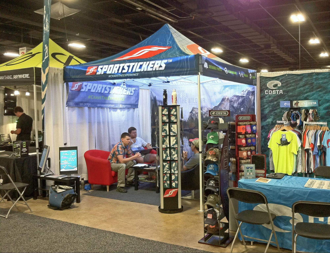 Custom trade show tent for SportStickers, with vibrant displays and merchandise, at a busy expo