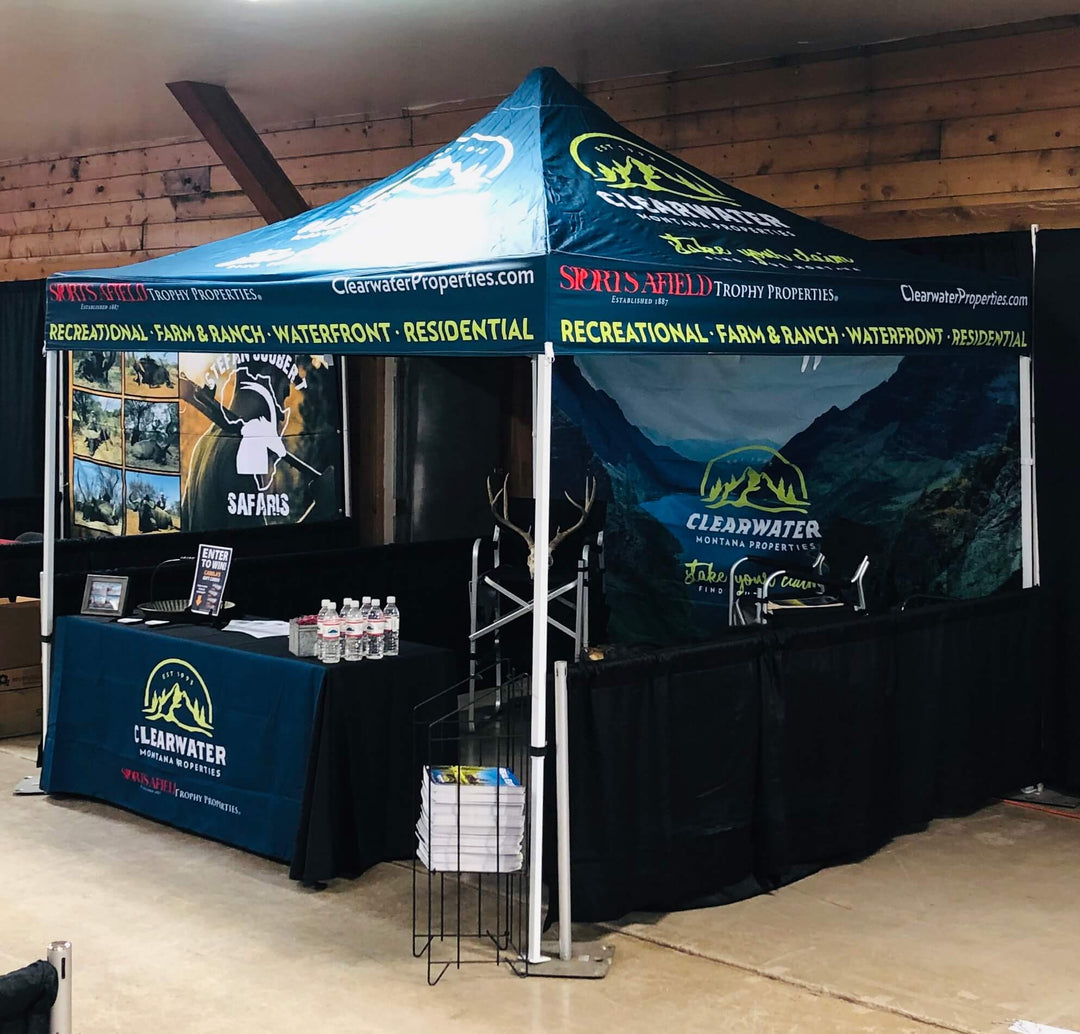 Display tents for trade shows, featuring Clearwater Montana Properties, with a wilderness-themed backdrop and informative setup
