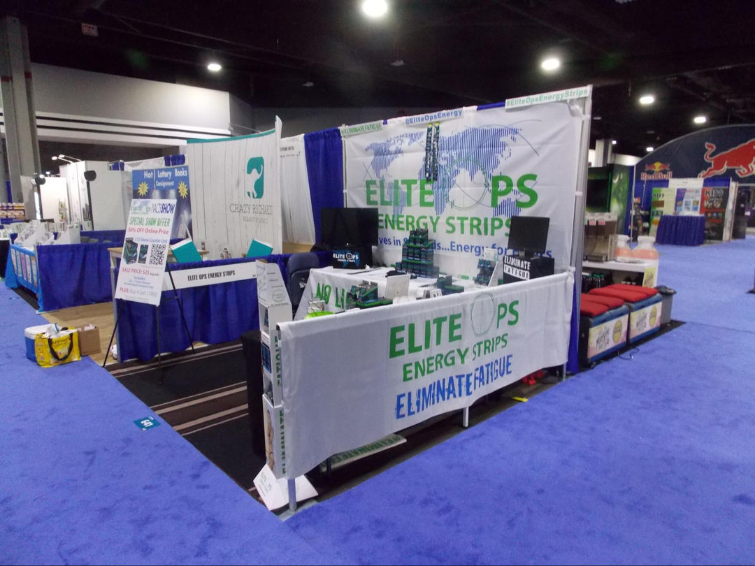 Elite Ops booth at trade show with custom logo backdrop wall and products displayed