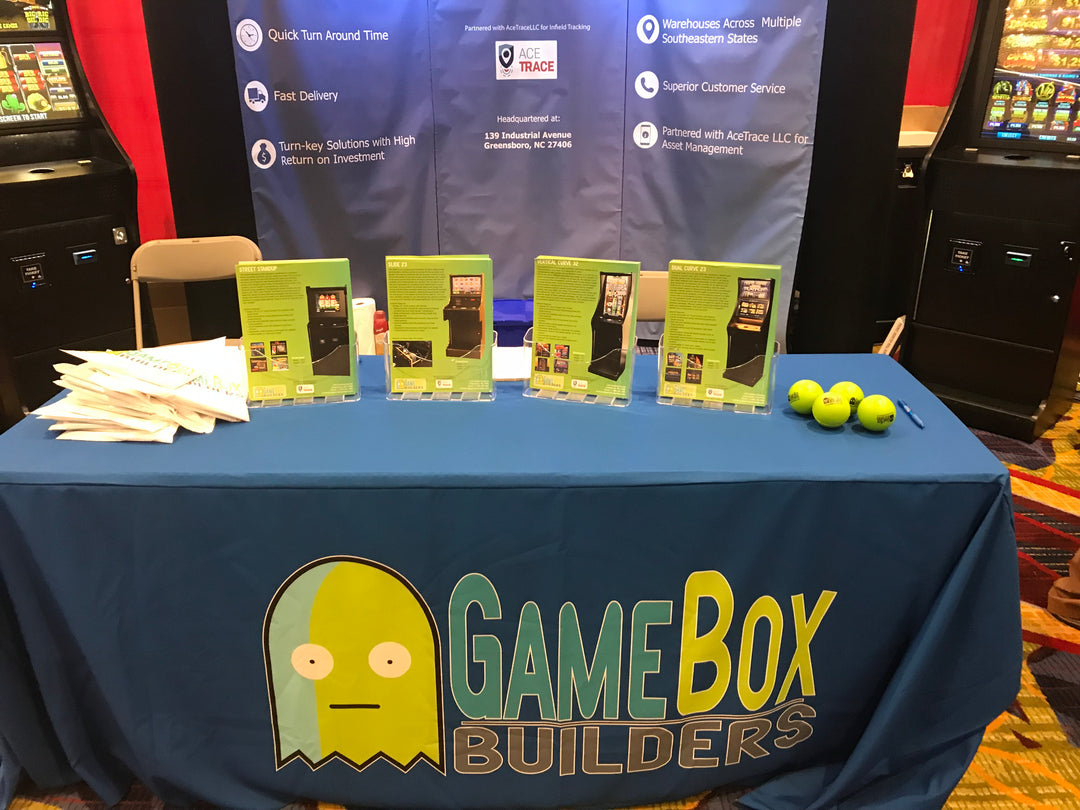 Blue trade show table throw featuring GAME BOX BUILDERS logo with a quirky yellow character design