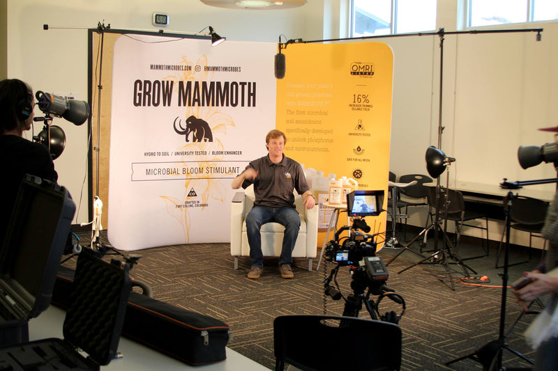 media interview setup with a man in front of a curved tension fabric backdrop for Grow Mammoth