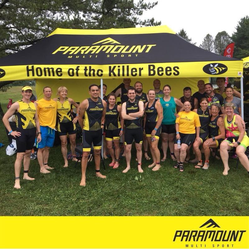 10 x 20 canopy tent customized for paramount multisport with attendees posing in front