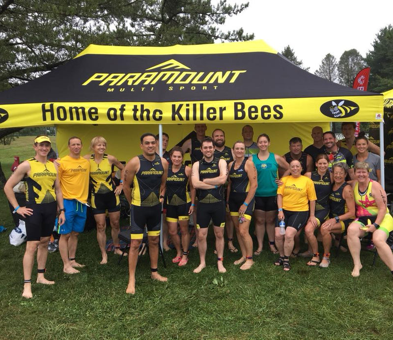 10 x 20 canopy tent customized for paramount multisport with attendees posing in front
