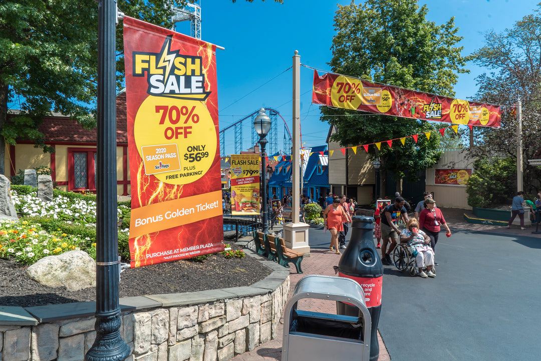 Colorful 70% Off Flash Sale banners prominently displayed at the theme park entry highlighting discounts and a special golden ticket offer