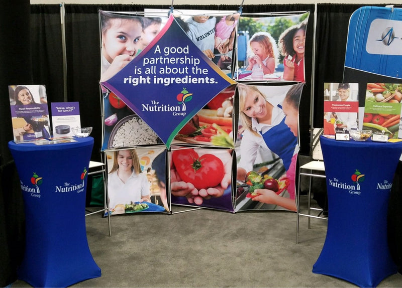 Two custom podiums and vertical banners at a Nutrition Group trade show booth with engaging graphics.