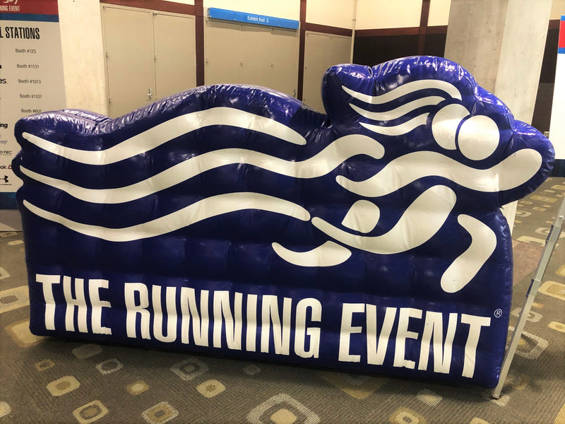 Blue giant inflatable logo for The Running Event in a conference hall
