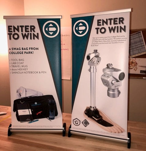 Two tabletop retractable banners for College Park's Enter to Win contest, displaying prize details and prosthetic technology
