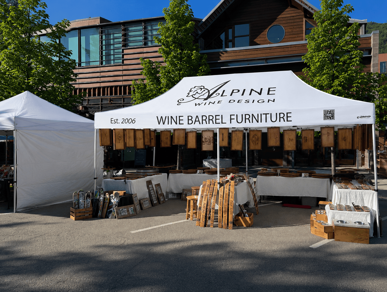 Alpine Wine Design custom canopy tent with wine barrel furniture display at outdoor artisan market