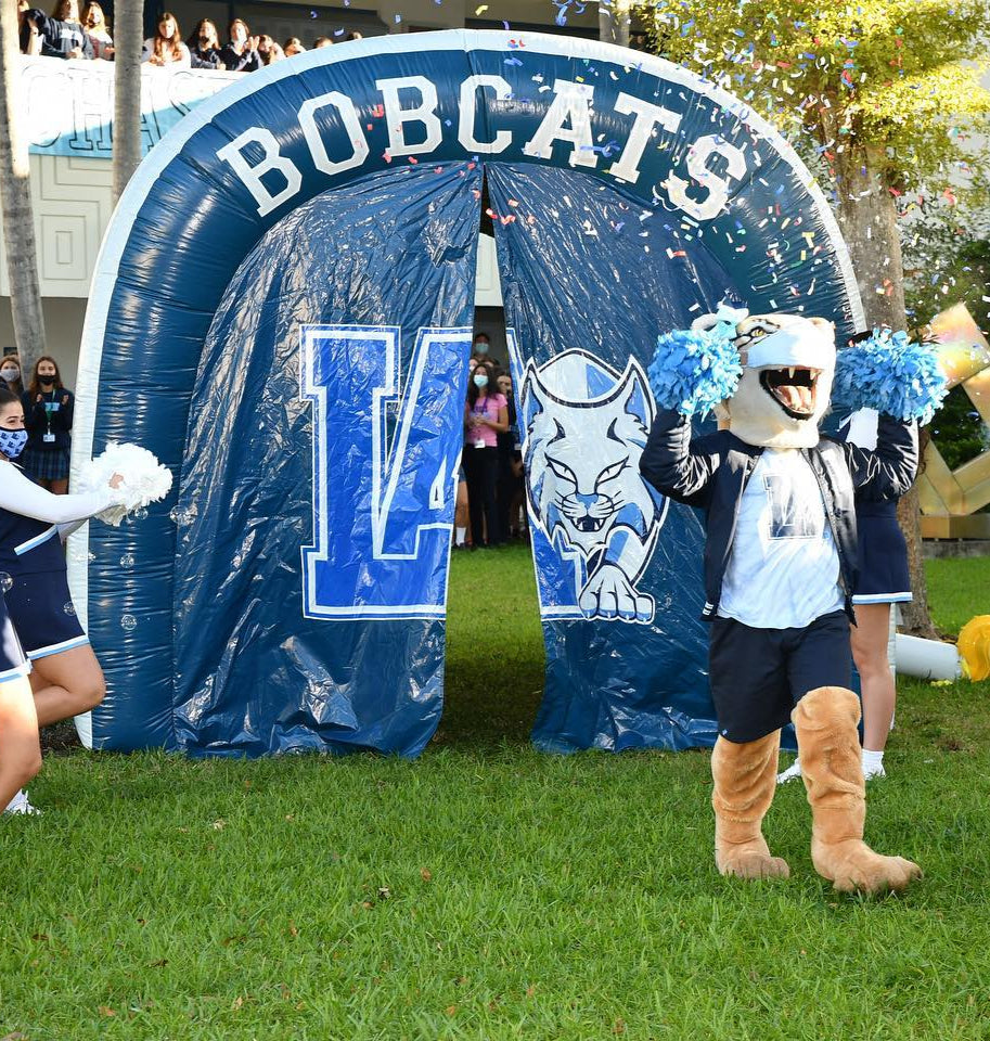 Blue inflatable tunnel with Bobcats mascot and cheerleaders at Our Lady of Lourdes Academy school spirit event