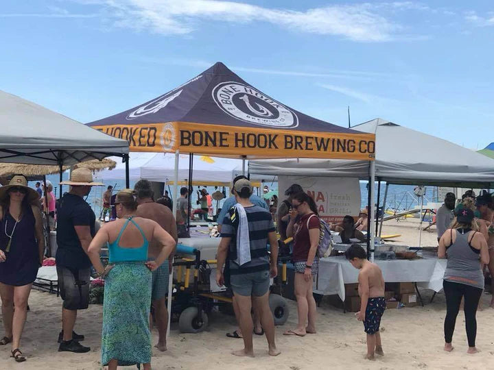 Bone Hook Brewing custom canopy tent at crowded beach festival with branded setup and summer event attendees