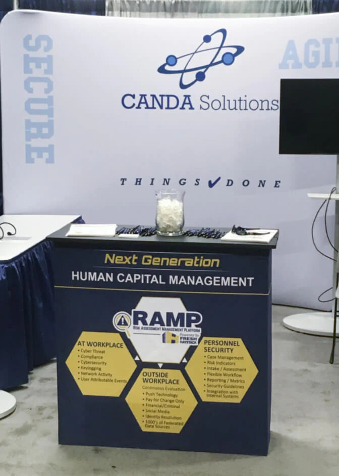 CANDA Solutions trade show booth with a tension fabric backdrop banner