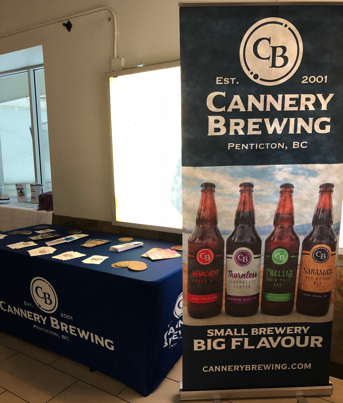 Cannery Brewing roll up banner showcasing four beer bottles and slogan “Small Brewery Big Flavour” next to branded table display