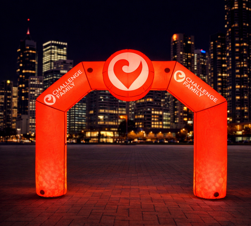 Red LED inflatable arch with Challenge Family logo set up at a nighttime city event