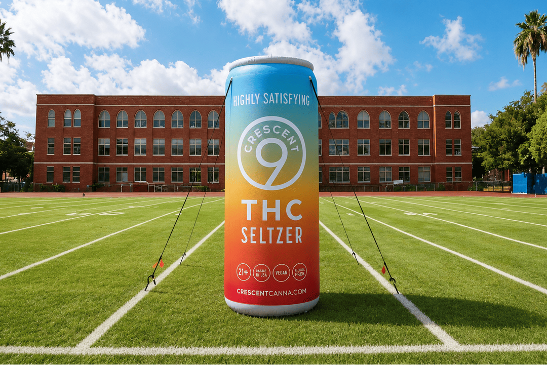 Inflatable can of Crescent 9 THC Seltzer on a sports field with a school building in the background