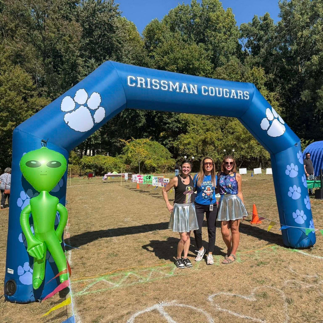Blue inflatable arch with "Crissman Cougars" and paw prints at outdoor school event