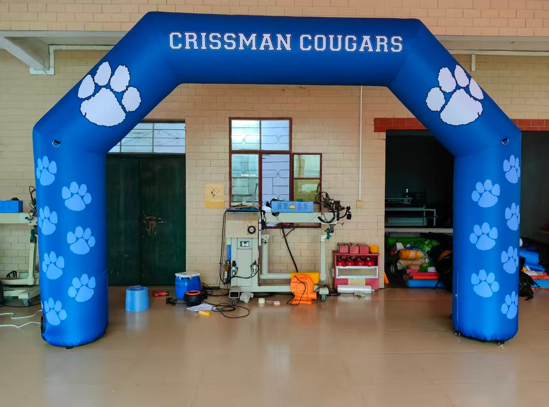Blue inflatable arch with paw prints and 'Crissman Cougars' text