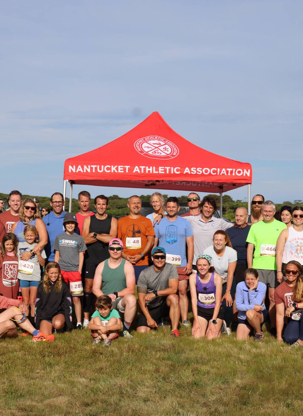 Group photo in front of a custom canopy tent at Nantucket Athletic Association event, featuring MVP Visuals branded pop-up tent