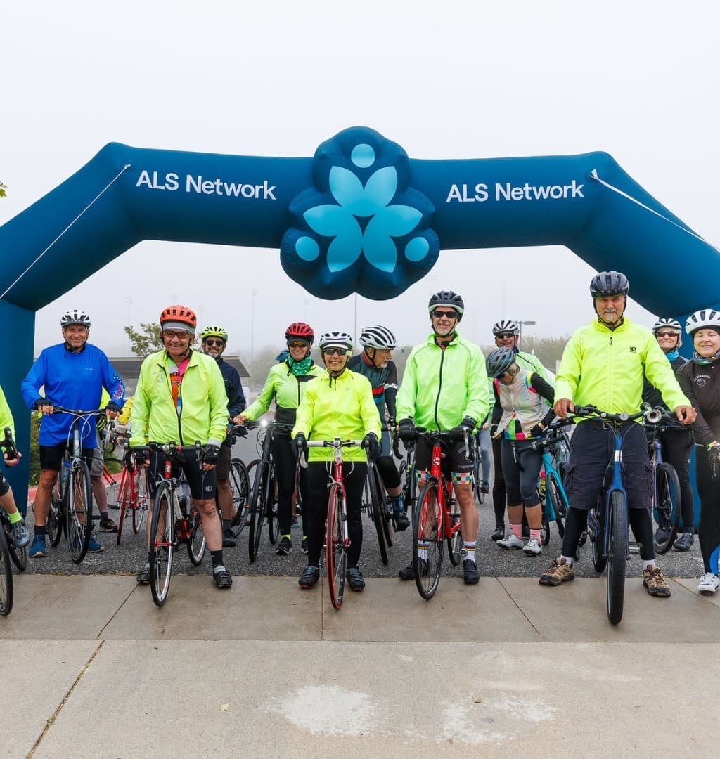 Cyclists gathered under custom inflatable arch for ALS Network charity bike ride event