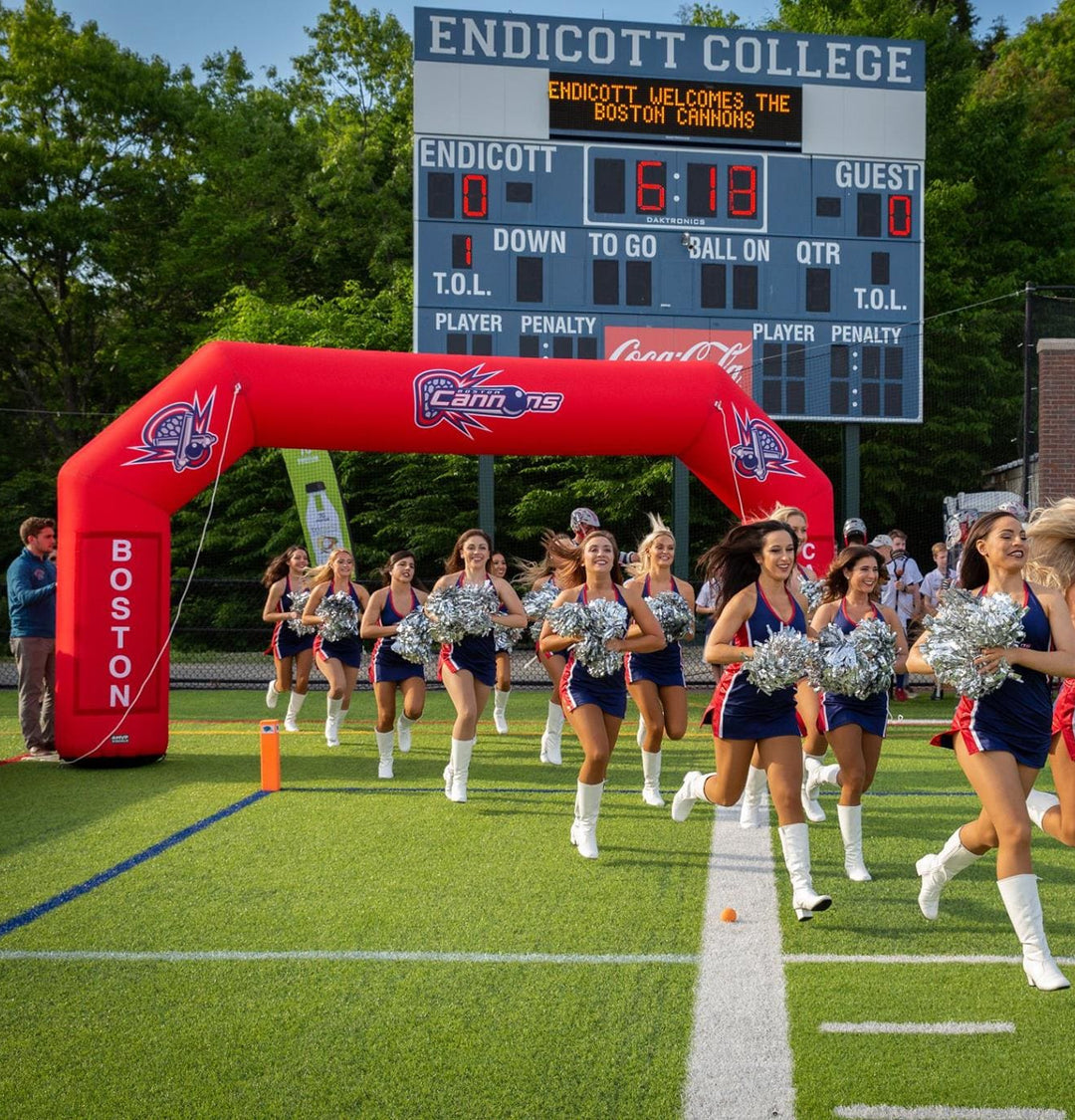 Cheerleaders running through custom red inflatable arch at Boston Cannons game at Endicott College