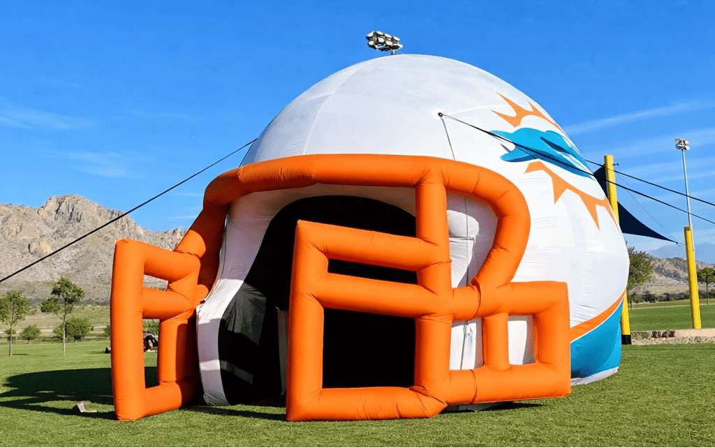 Custom inflatable football helmet entrance tunnel set up on a sports field for team introductions