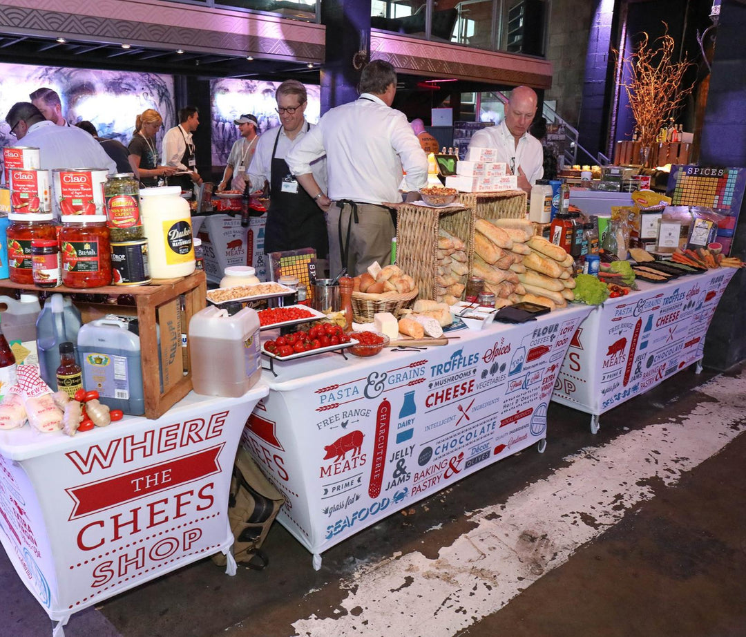 Custom stretch table spandex covers for The Chef's Warehouse food showcase with artisan ingredients and vendor display