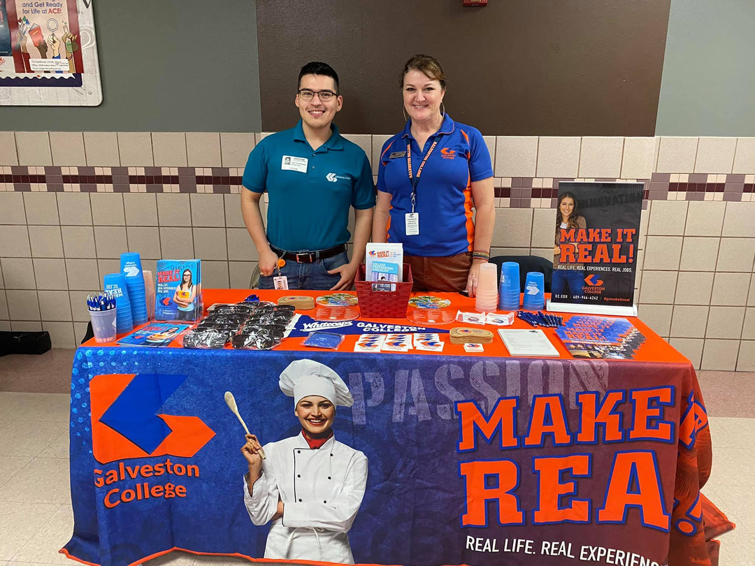 Custom printed table cover for Galveston College recruitment event with educational materials and giveaways