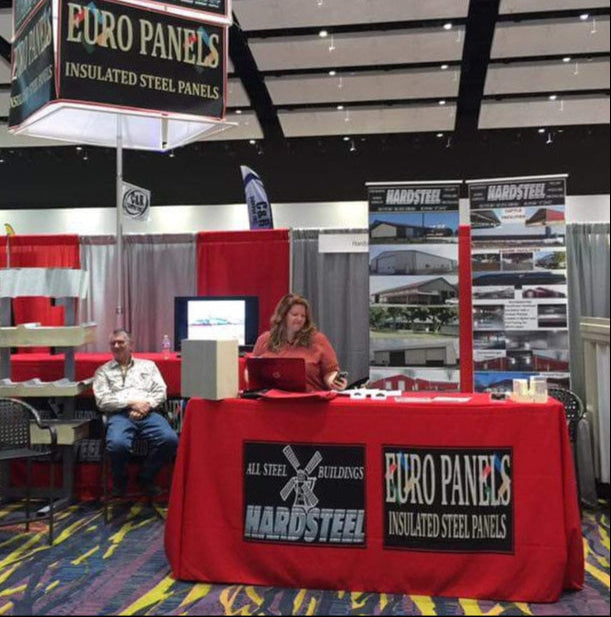 Custom red table cover with Hardsteel and Euro Panels branding at trade show booth for insulated steel panels
