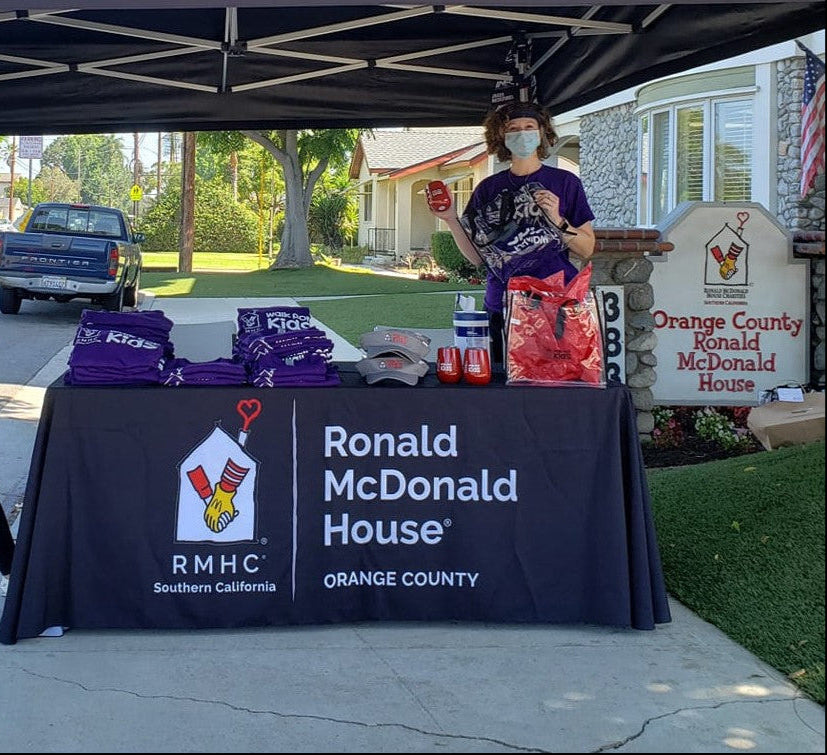 Custom black table cover for Ronald McDonald House Orange County at outdoor community event with branded giveaways