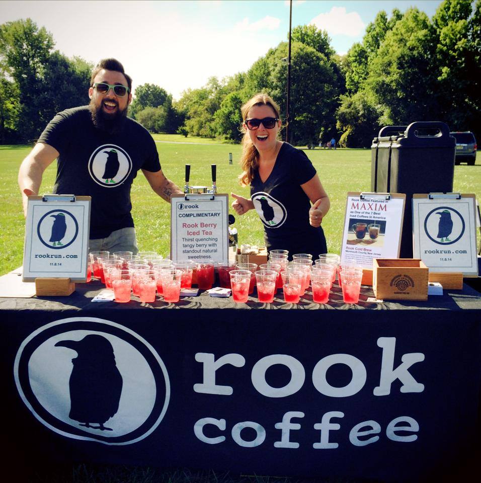 Custom black table cover for Rook Coffee outdoor sampling event with iced tea and cold brew display
